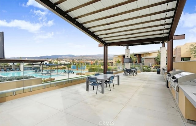 1521 Summerfield Way, Beaumont, CA 92223 - view of patio with exterior kitchen, a community pool, a mountain view, and outdoor dining space