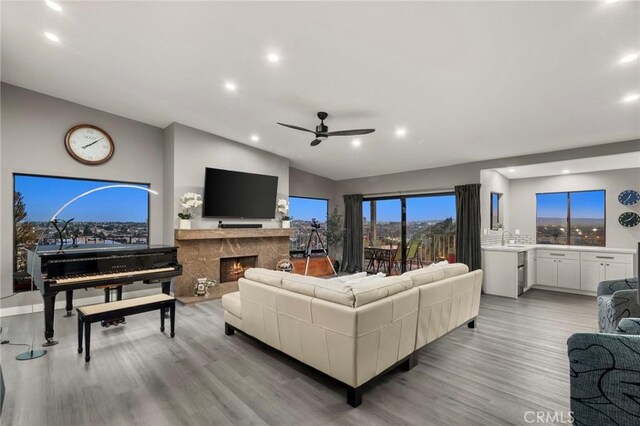 1995 Molino Ave Unit 301, Signal Hill, CA 90755 - living area featuring a ceiling fan, light wood finished floors, recessed lighting, vaulted ceiling, and a high end fireplace