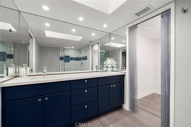 1995 Molino Ave Unit 301, Signal Hill, CA 90755 - bathroom with wood finished floors, a shower stall, double vanity, a skylight, and recessed lighting