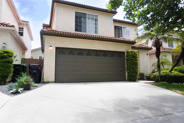 14678 Tupper St, Panorama City, CA 91402 - mediterranean / spanish-style house featuring a garage, driveway, stucco siding, and a tile roof