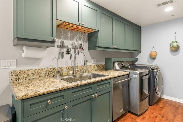 17230 Newhope St Unit 309, Fountain Valley, CA 92708 - washroom with washer and dryer, light wood-style flooring, cabinet space, baseboards, and wet bar