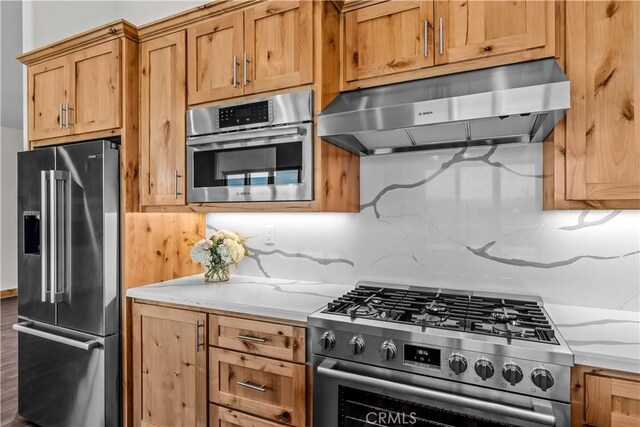851 Madera Ln, Lake Arrowhead, CA 92352 - kitchen with stainless steel appliances, under cabinet range hood, tasteful backsplash, and light stone countertops