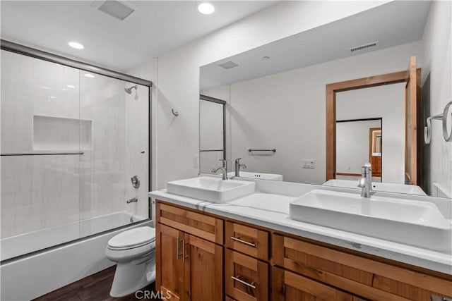 851 Madera Ln, Lake Arrowhead, CA 92352 - bathroom with toilet, double vanity, bath / shower combo with glass door, wood finished floors, and recessed lighting