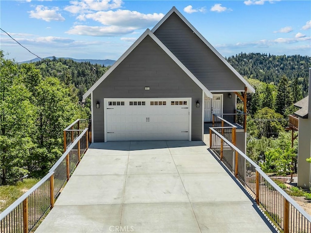 851 Madera Ln, Lake Arrowhead, CA 92352 - view of front of house featuring a forest view, concrete driveway, and a garage