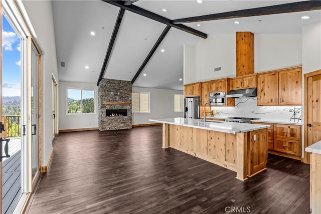 851 Madera Ln, Lake Arrowhead, CA 92352 - kitchen featuring under cabinet range hood, stainless steel fridge with ice dispenser, open floor plan, high vaulted ceiling, and light countertops