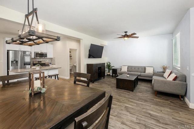 1710 Moon Orchid Ave, Chula Vista, CA 91913 - dining room with ceiling fan, light wood-style floors, a fireplace, and baseboards