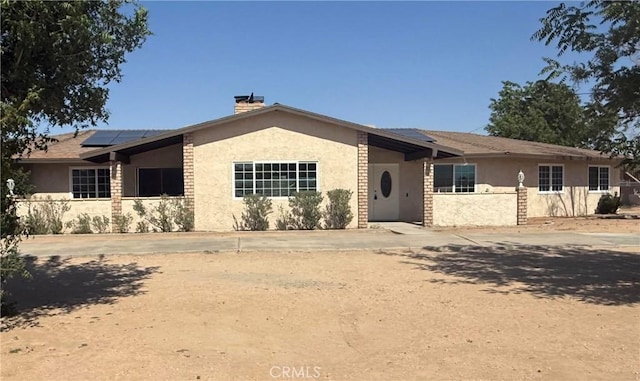 15615 Apache Rd, Apple Valley, CA 92307 - ranch-style house featuring stucco siding, roof mounted solar panels, and a chimney