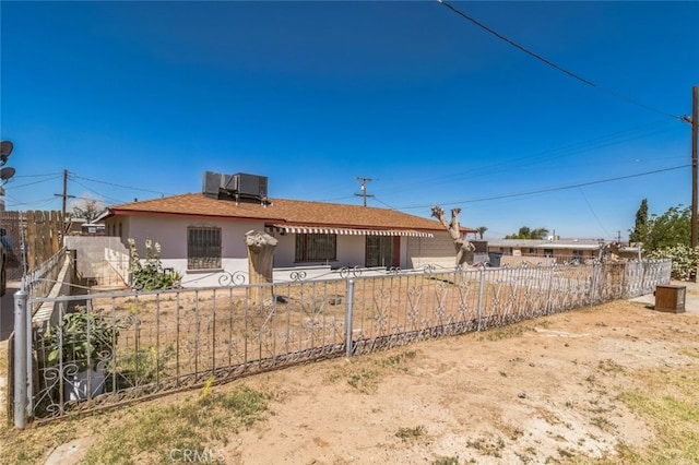 34540 Western Dr, Barstow, CA 92311 - ranch-style house featuring a fenced front yard, a shingled roof, stucco siding, and central AC unit