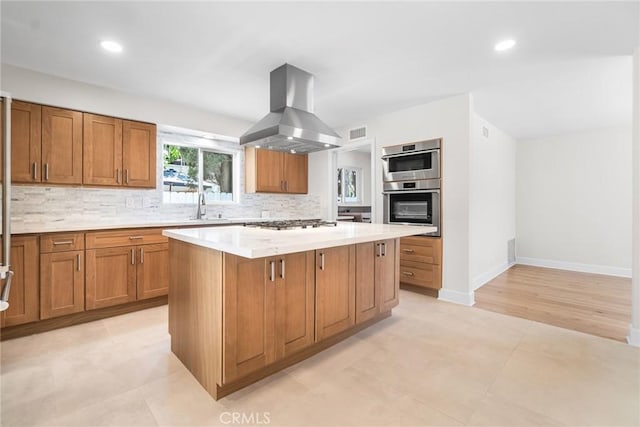 18311 Chase St, Northridge, CA 91325 - kitchen featuring island exhaust hood, a center island, backsplash, brown cabinets, and recessed lighting