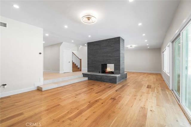 18311 Chase St, Northridge, CA 91325 - unfurnished living room with a multi sided fireplace, light wood-style flooring, baseboards, stairs, and recessed lighting