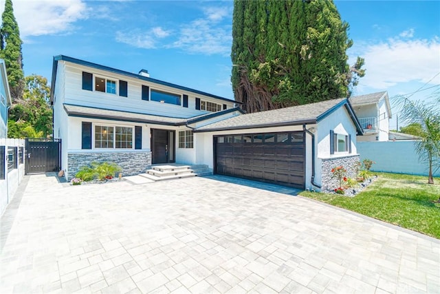 18311 Chase St, Northridge, CA 91325 - view of front of property featuring a garage, stone siding, a gate, driveway, and stucco siding