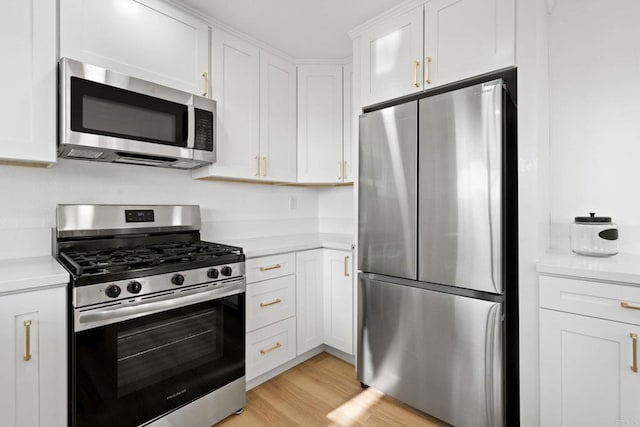 2858 Lehigh Ct, Oceanside, CA 92056 - kitchen with stainless steel appliances, light countertops, white cabinetry, and light wood-type flooring