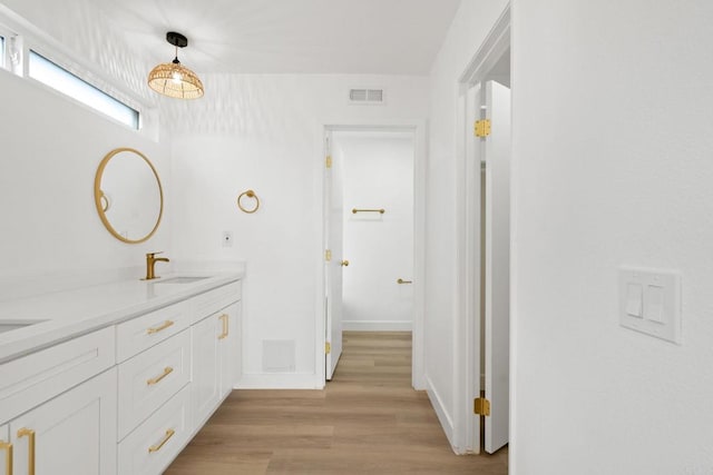 2858 Lehigh Ct, Oceanside, CA 92056 - bathroom with double vanity, wood finished floors, and baseboards