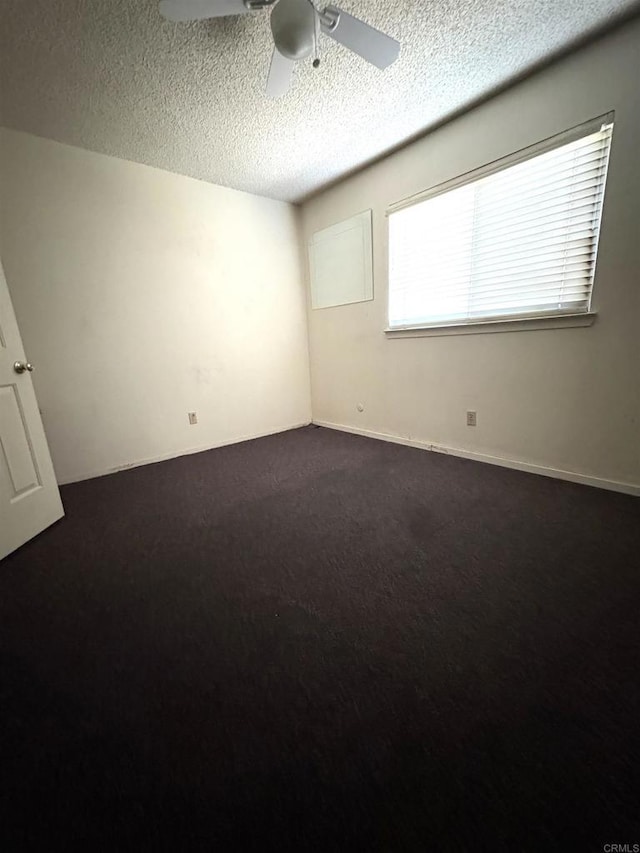 6049 N Constance Ave, Fresno, CA 93722 - empty room featuring ceiling fan, a textured ceiling, and dark carpet