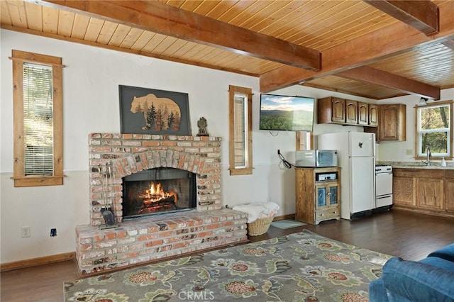 33133 Ridge Rd, Arrowbear, CA 92382 - living room featuring wooden ceiling with exposed beams, dark wood-style flooring, baseboards, and a brick fireplace