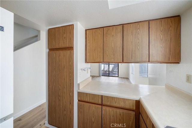 2975 Rockview Pl # 2, San Luis Obispo, CA 93401 - kitchen featuring light countertops, light wood finished floors, and brown cabinetry