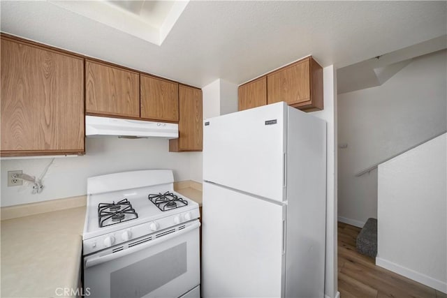 2975 Rockview Pl # 2, San Luis Obispo, CA 93401 - kitchen featuring white appliances, under cabinet range hood, wood finished floors, light countertops, and brown cabinetry