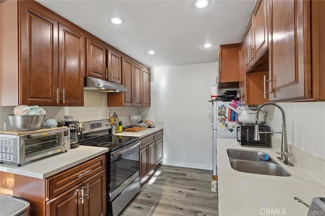 15500 Tustin Village Way Unit 28, Tustin, CA 92780 - kitchen featuring stainless steel electric range oven, under cabinet range hood, a sink, light countertops, and recessed lighting