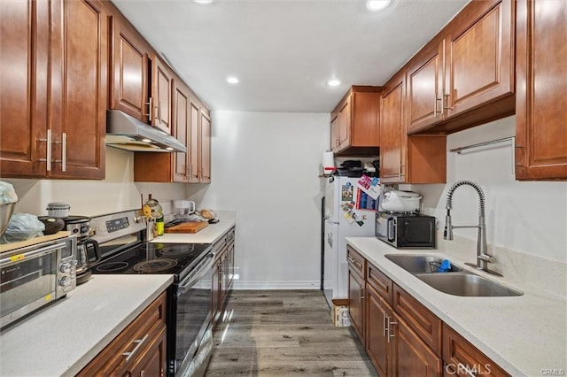 15500 Tustin Village Way Unit 28, Tustin, CA 92780 - kitchen with stainless steel range with electric stovetop, under cabinet range hood, a sink, wood finished floors, and recessed lighting