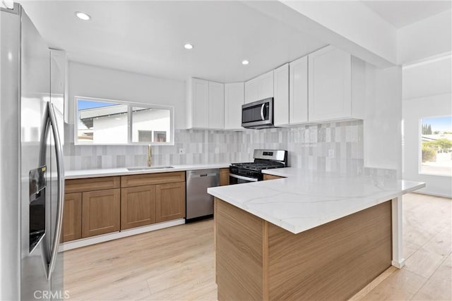 15447 Romar St, Mission Hills San Fernando, CA 91345 - kitchen featuring appliances with stainless steel finishes, a sink, a peninsula, tasteful backsplash, and light stone counters