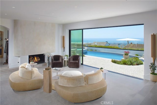 17 Muir Beach Cir, Corona Del Mar, CA 92625 - living area with a fireplace, arched walkways, recessed lighting, and a water view