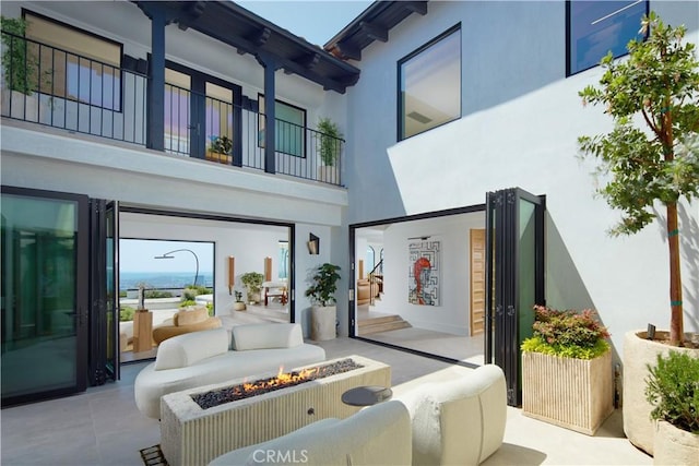17 Muir Beach Cir, Corona Del Mar, CA 92625 - back of house featuring a fire pit, stucco siding, and a balcony
