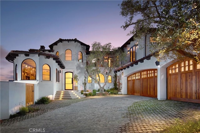17 Muir Beach Cir, Corona Del Mar, CA 92625 - mediterranean / spanish house with stucco siding, decorative driveway, and an attached garage