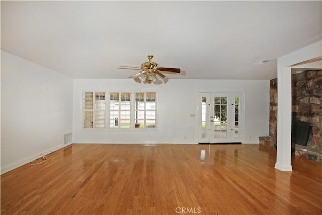 7228 Bairnsdale St, Downey, CA 90240 - unfurnished living room featuring ceiling fan, light wood-style floors, baseboards, and a stone fireplace