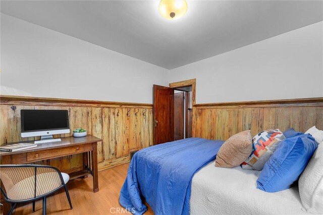 4039 W 7th St, Los Angeles, CA 90005 - bedroom featuring wainscoting, wooden walls, wood finished floors, and a desk