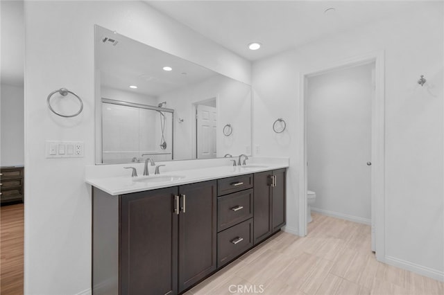 11757 Stonefield Dr, Corona, CA 92883 - bathroom with double vanity, toilet, an enclosed shower, baseboards, and recessed lighting