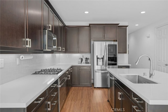 11757 Stonefield Dr, Corona, CA 92883 - kitchen with appliances with stainless steel finishes, a sink, wood finished floors, light countertops, and dark brown cabinetry