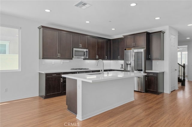 11757 Stonefield Dr, Corona, CA 92883 - kitchen with appliances with stainless steel finishes, a sink, light countertops, light wood-style floors, and dark brown cabinets