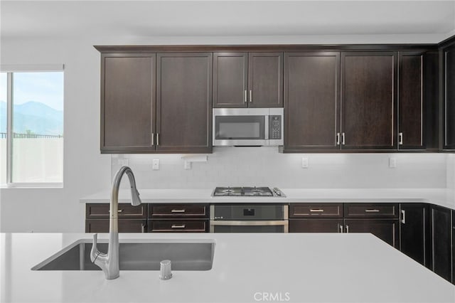 11757 Stonefield Dr, Corona, CA 92883 - kitchen featuring stainless steel appliances, a sink, light countertops, and dark brown cabinetry