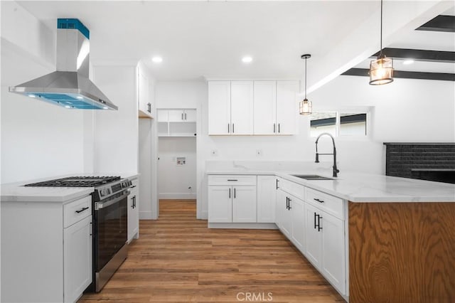 424 E Victoria St, Rialto, CA 92376 - kitchen featuring stainless steel range with gas cooktop, a sink, ventilation hood, a peninsula, and white cabinetry