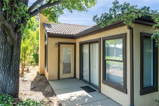 9 Coolwater, Chico, CA 95928 - property entrance with stucco siding, a tile roof, and a patio area