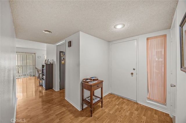 5359 Algarrobo Unit 1A, Laguna Woods, CA 92637 - entryway featuring light wood-type flooring, a textured ceiling, and baseboards