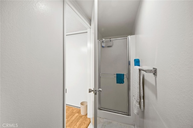 5359 Algarrobo Unit 1A, Laguna Woods, CA 92637 - bathroom featuring a stall shower, wood finished floors, and a textured wall
