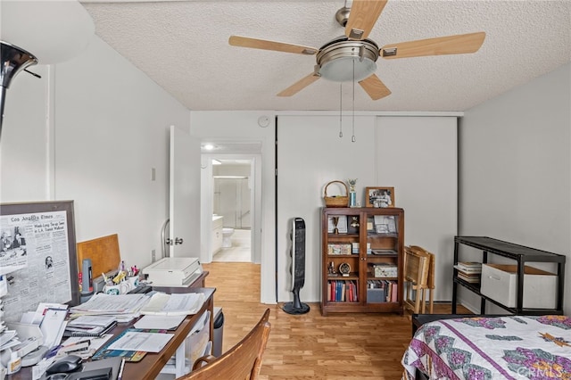 5359 Algarrobo Unit 1A, Laguna Woods, CA 92637 - bedroom featuring a textured ceiling, light wood-type flooring, a ceiling fan, and ensuite bathroom