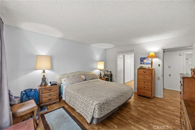 5359 Algarrobo Unit 1A, Laguna Woods, CA 92637 - bedroom featuring a textured ceiling, wood finished floors, a closet, and baseboards