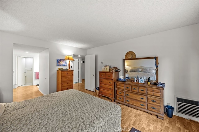 5359 Algarrobo Unit 1A, Laguna Woods, CA 92637 - bedroom featuring heating unit, wood finished floors, and a textured ceiling