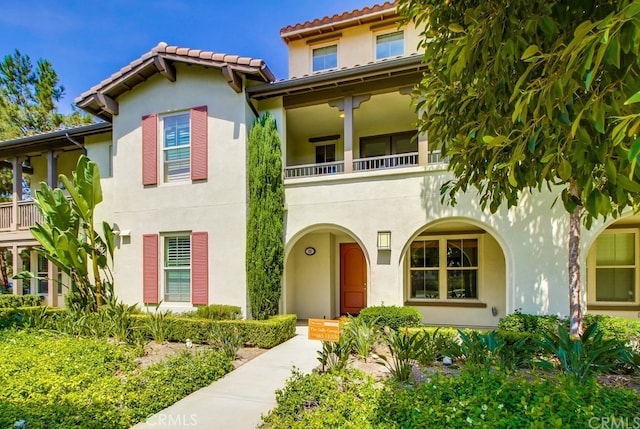 23 Crosspointe, Irvine, CA 92618 - mediterranean / spanish house featuring stucco siding, a balcony, and a tiled roof