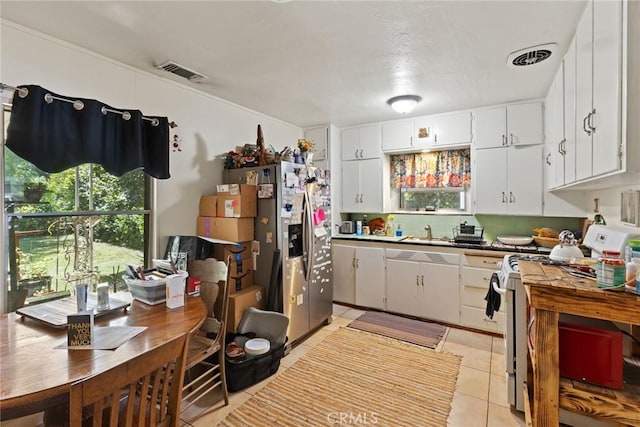393 E 9th Ave, Chico, CA 95926 - kitchen with gas range gas stove, stainless steel refrigerator with ice dispenser, white cabinetry, light tile patterned floors, and a sink