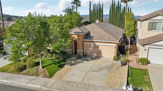 28523 Santa Catarina Rd, Saugus, CA 91350 - view of front of property featuring a tiled roof, concrete driveway, an attached garage, stucco siding, and a mountain view
