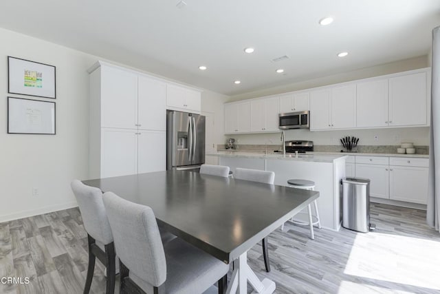 1607 Dundas Pl, Upland, CA 91784 - kitchen with appliances with stainless steel finishes, white cabinetry, light wood-style flooring, and recessed lighting
