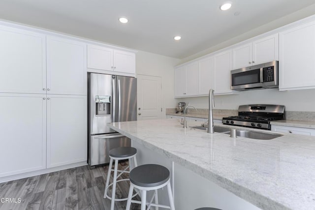 1607 Dundas Pl, Upland, CA 91784 - kitchen featuring appliances with stainless steel finishes, white cabinetry, light stone countertops, recessed lighting, and a breakfast bar area