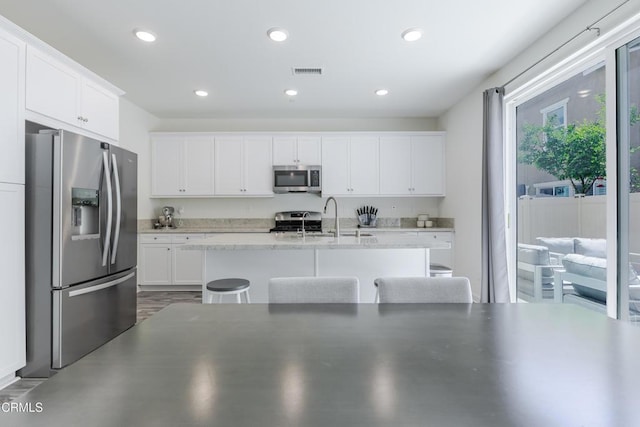 1607 Dundas Pl, Upland, CA 91784 - kitchen featuring stainless steel appliances, white cabinets, a sink, an island with sink, and recessed lighting