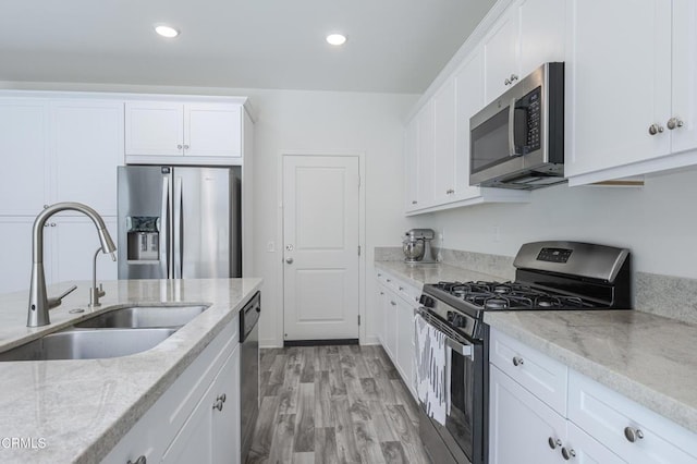 1607 Dundas Pl, Upland, CA 91784 - kitchen featuring appliances with stainless steel finishes, a sink, white cabinetry, light wood finished floors, and light stone countertops