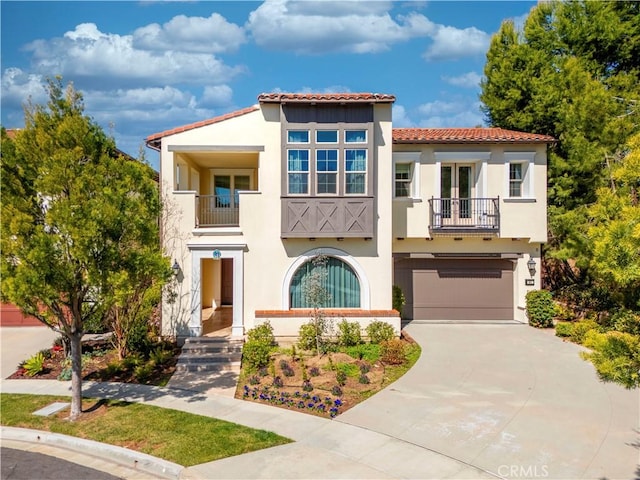 51 Dunmore, Irvine, CA 92620 - mediterranean / spanish-style house featuring a balcony, stucco siding, a tile roof, concrete driveway, and a garage