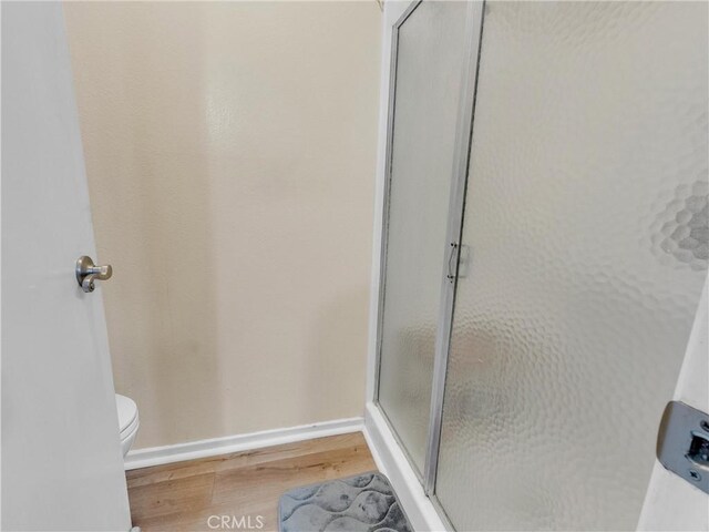 23403 Via Castanet, Valencia, CA 91355 - full bath featuring wood finished floors, a shower stall, toilet, and baseboards