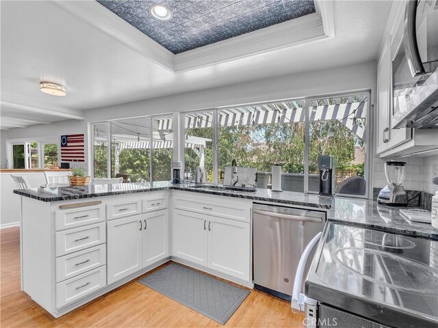 23403 Via Castanet, Valencia, CA 91355 - kitchen featuring appliances with stainless steel finishes, a sink, white cabinets, light wood-style flooring, and dark stone counters